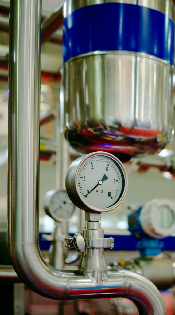 Industrial piping with pressure gauge in a utility system.